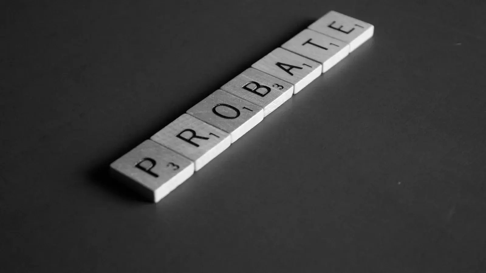Letter tiles spelling PROBATE on a dark surface